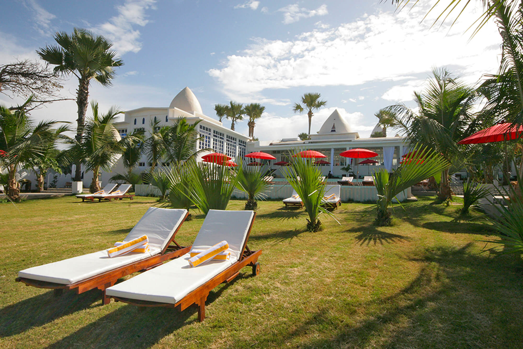 Ligbedden in de tuin van het Coco Ocean Resort en Spa hotel in Gambia