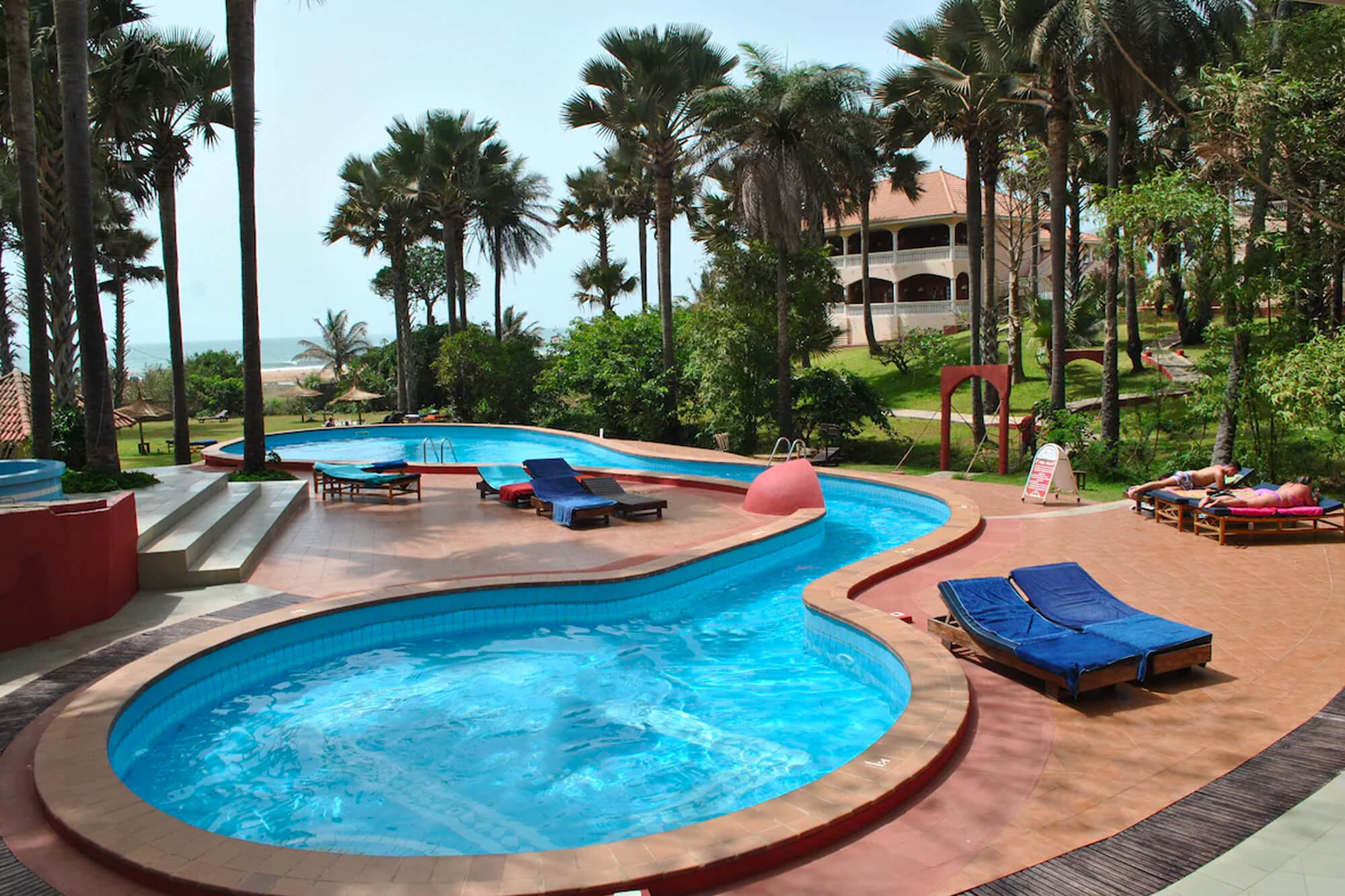 Zwembad met ligbedden bij het Lemon Creek hotel en resort in Gambia in Bijilo