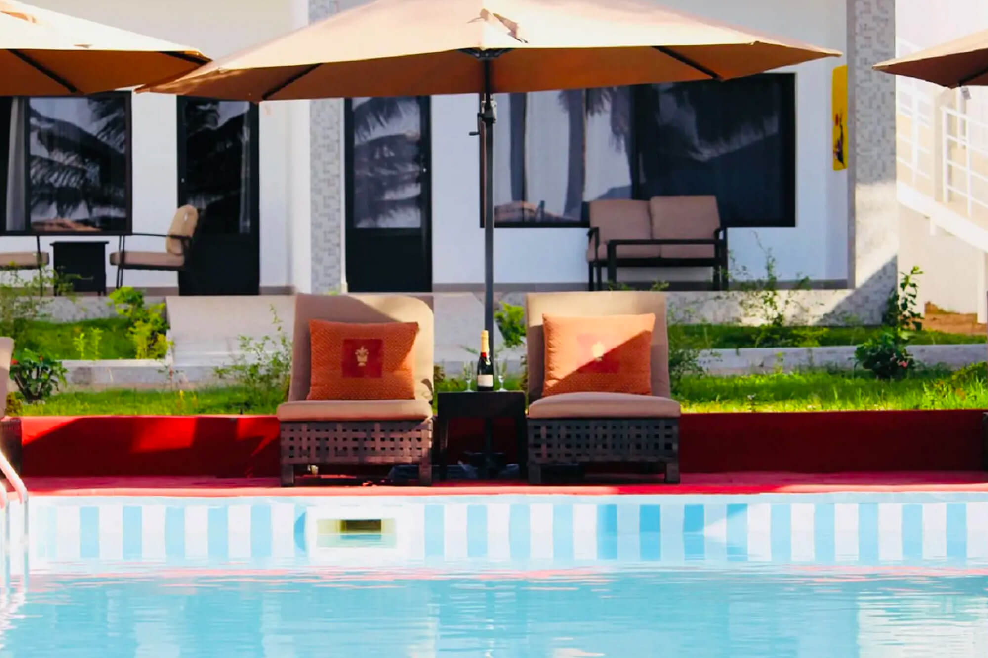 Ligbedden aan het zwembad van Swiss Boutique Hotel in Bijilo, Gambia