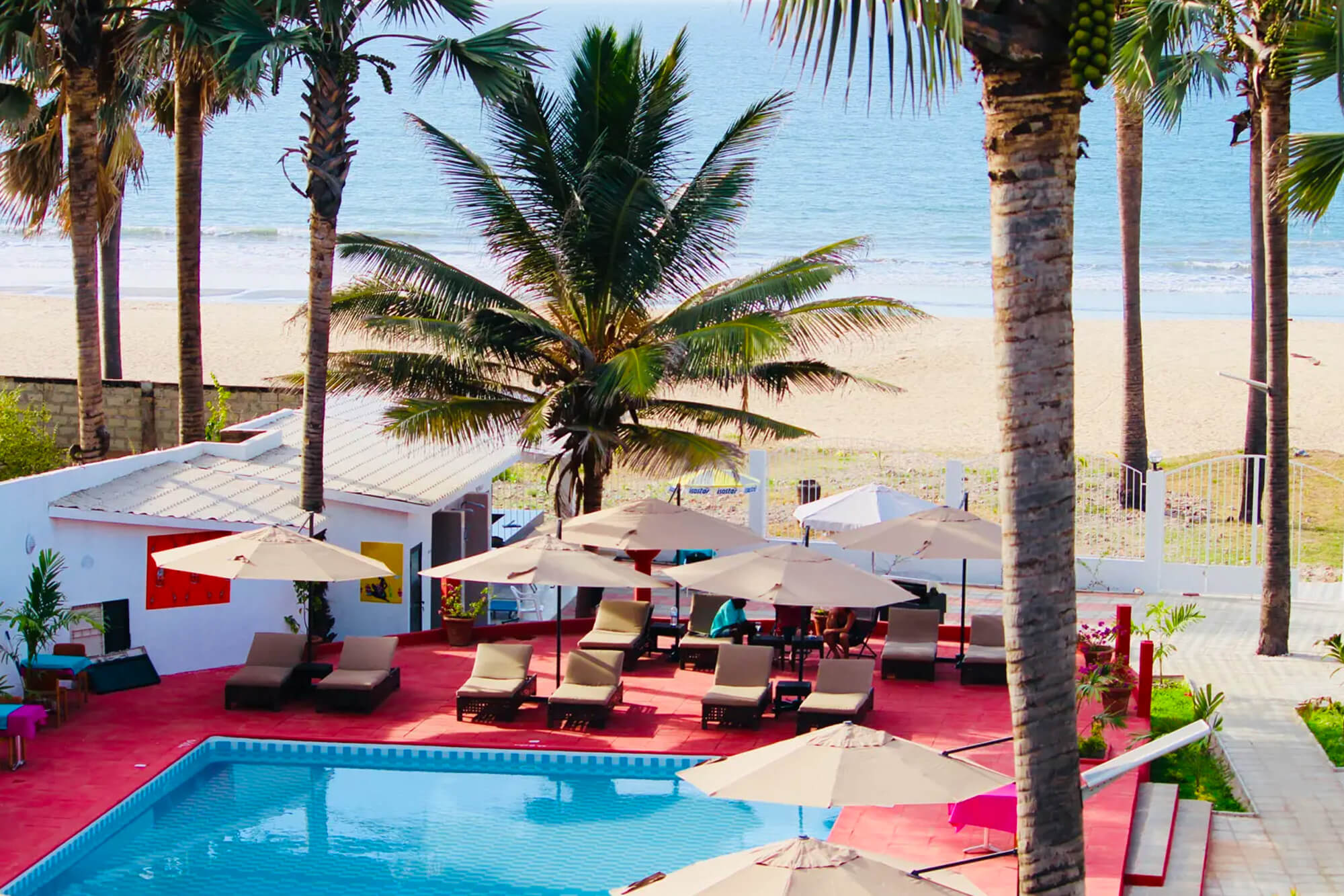 Zwembad, ligbedden en strand bij het Swiss Boutique Hotel in Bijilo, Gambia